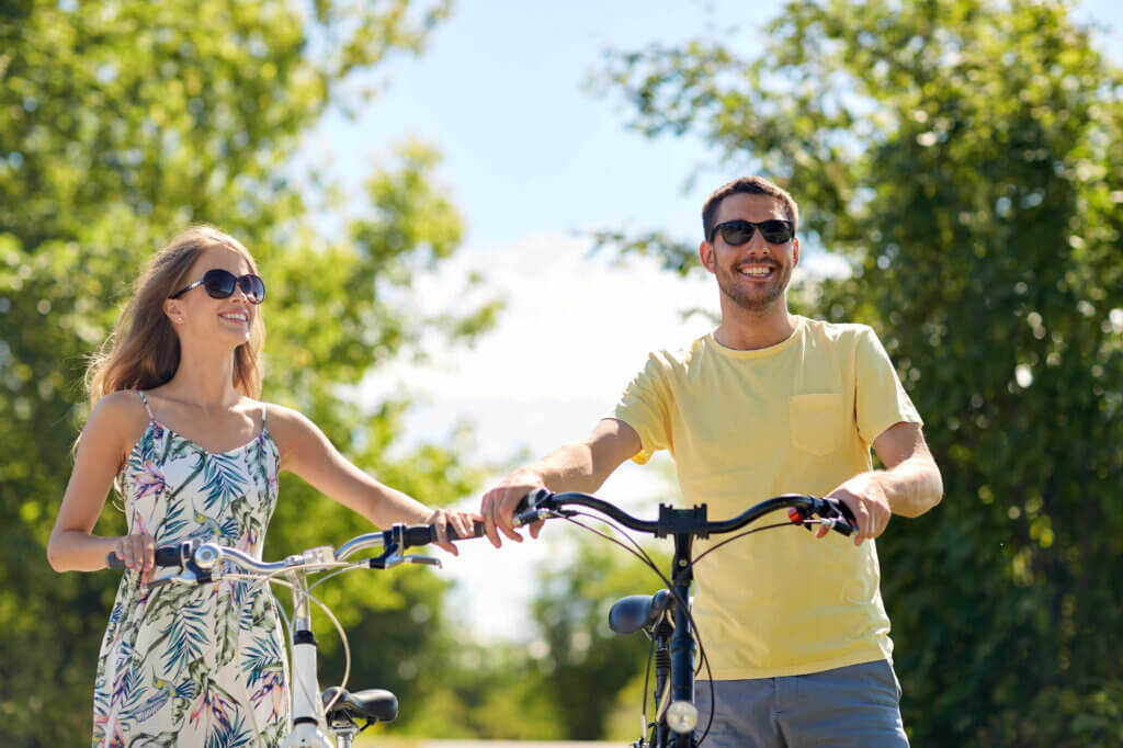 a couple pushing bikes smiling